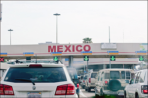 U.S.-Mexican Border With Cars Waiting, with Mexico Sign Posted Above Lanes